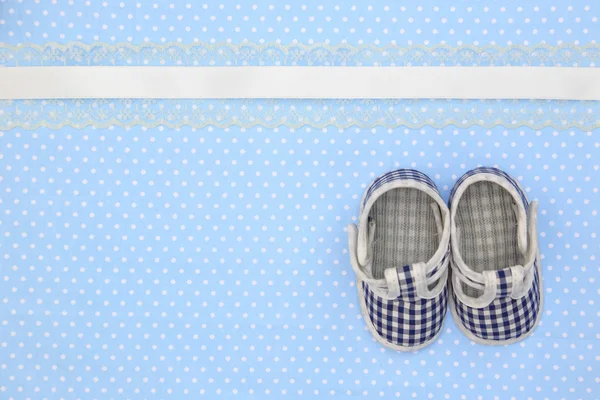 Baby schoenen op blauwe polka dots achtergrond — Stockfoto