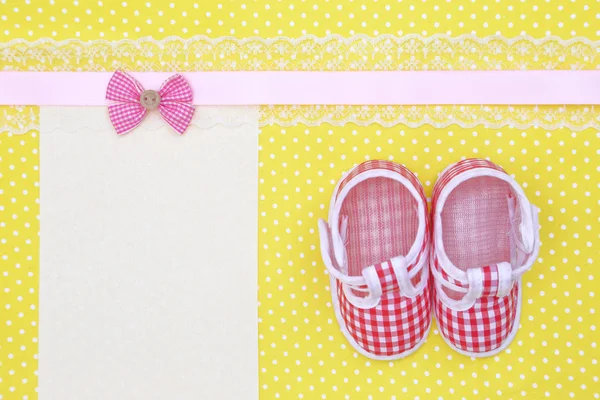 Baby shoes and blank banner on polka dots background