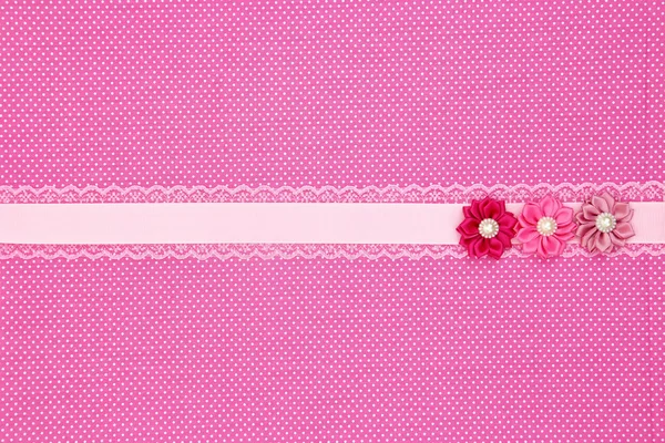Pink polka dot textile background with ribbon and flowers — Stock Photo, Image