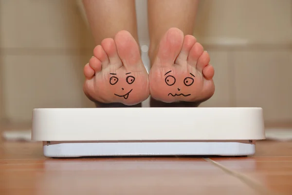 Pies en escala de baño con caras lindas dibujadas a mano — Foto de Stock