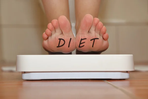 Feet on bathroom scale with hand drawn Diet text — Stock Photo, Image