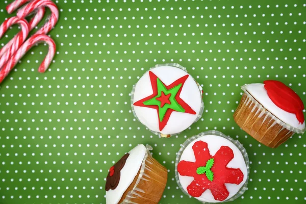 Feestelijke kerst cakejes en snoep stokken op groene achtergrond — Stockfoto