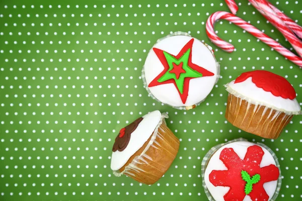 Pastelitos navideños festivos y bastones de caramelo sobre fondo verde — Foto de Stock