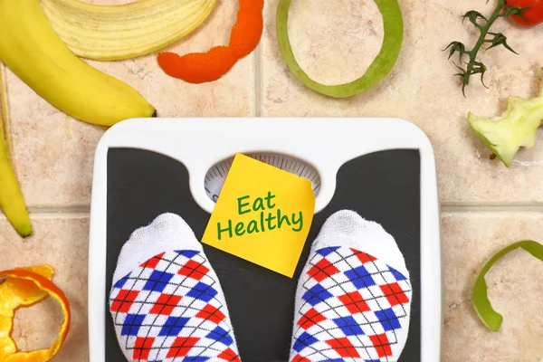Nohy v koupelně měřítko se jíst zdravé ovoce textu vzdělanému a okolí — Stock fotografie