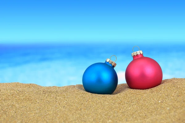 Christmas balls on sandy beach — Stock Photo, Image