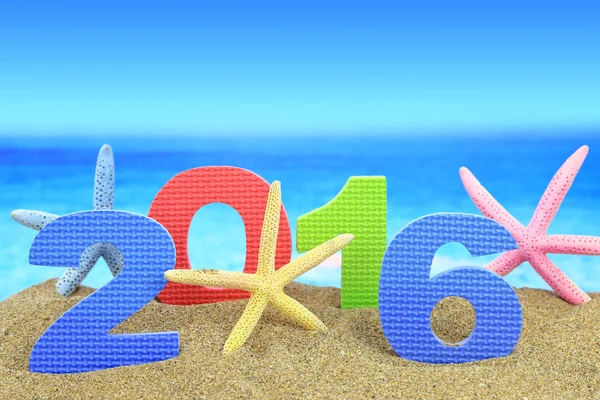 New year number 2016 and starfishes on the beach — Stock Photo, Image