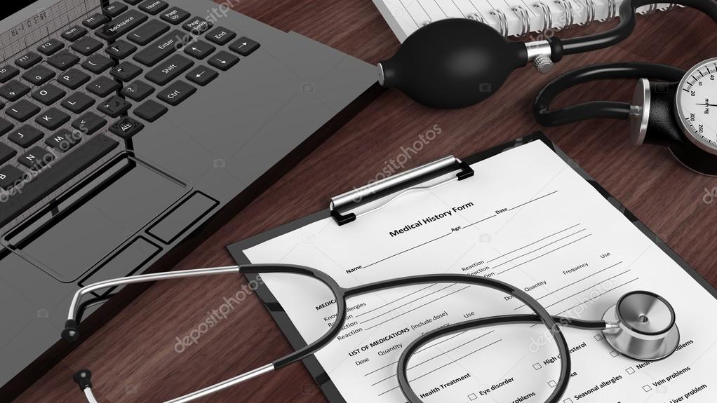 Laptop with medical instruments and patient form on desktop
