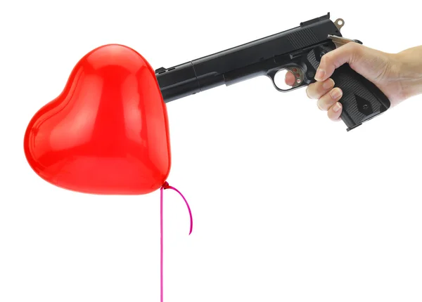 Hand holding at gunpoint a heart balloon isolated on white — Stock Photo, Image