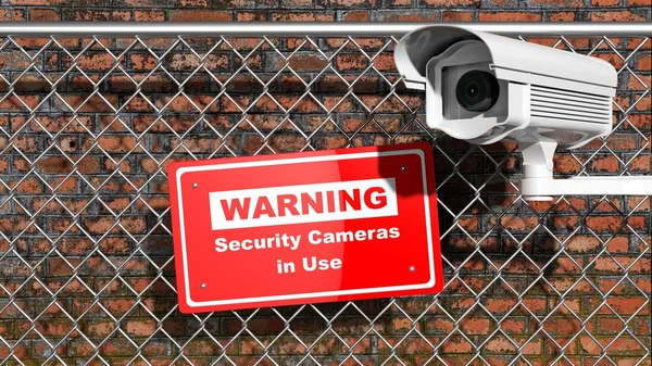 Камера наблюдения на заборе цепи с предупреждающим знаком — стоковое фото