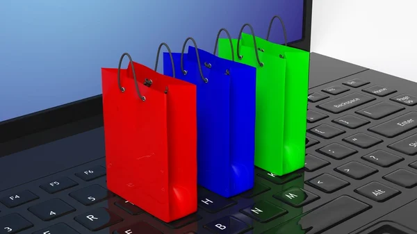 Bolsas de compras coloridas en el teclado negro portátil — Foto de Stock