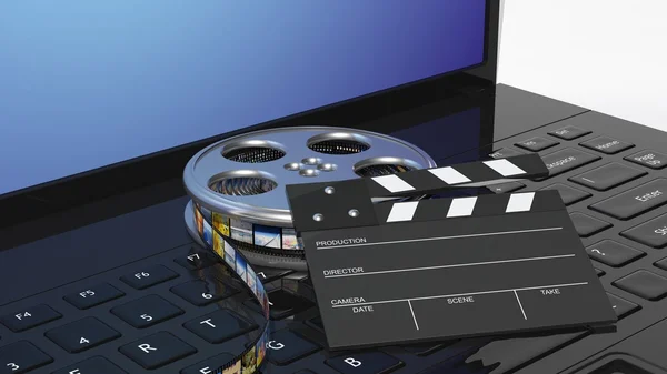 Filmklapper en film reel here reel op zwarte laptop toetsenbord — Stockfoto