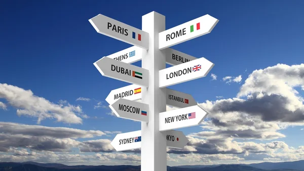 White signpost with various city names on blue sky background — Stock Photo, Image