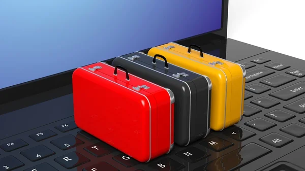 Colorful suitcases on black laptop keyboard with blank screen — Stock Photo, Image