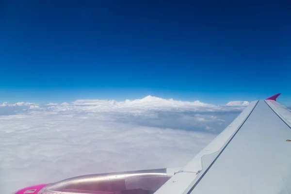 Blauwe horizon met wolken, lucht geschoten vanuit vliegtuig, met vleugel zichtbaar — Stockfoto