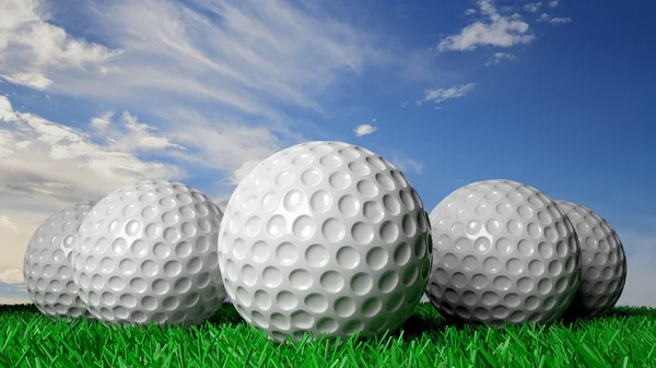 Golfballen op groen gras, met blauwe hemel in achtergrond — Stockfoto