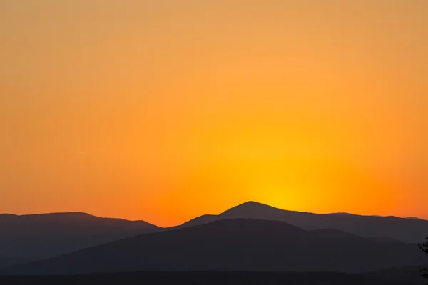 Vista panorámica de una hermosa puesta de sol naranja rica sobre las montañas —  Fotos de Stock