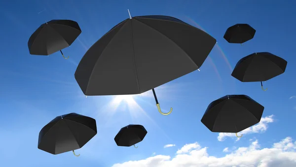 Classic black open umbrellas on blue sky with sun and some clouds background. — Stock Photo, Image