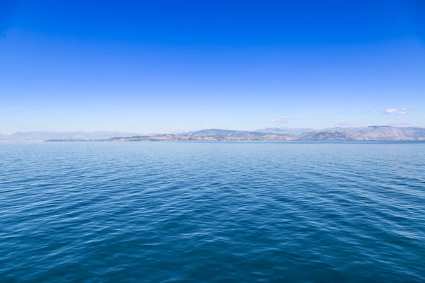 Deniz suları mavi ve mavi gökyüzü ile uzak bir diyarda temizleyin — Stok fotoğraf