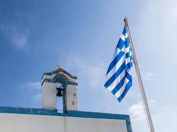 Ancien clocher d'une église avec drapeau national de la Grèce sur ciel bleu — Photo