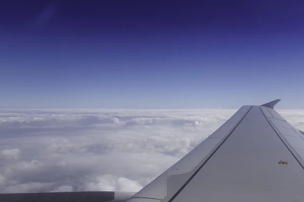 Aile d'avion au-dessus des nuages dans le ciel, vue de la fenêtre . — Photo