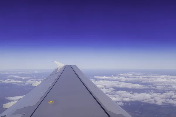 Wing av flygplan ovanför molnen på himlen, vy från fönstret. — Stockfoto