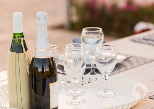 Botellas y copas de vino puestas en la mesa — Foto de Stock