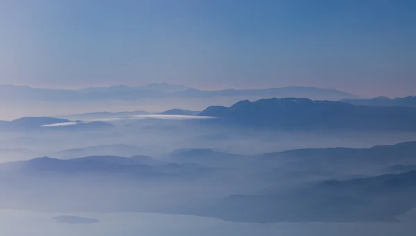 Amazing landscape of mountains weltered in mist — Stock Photo, Image