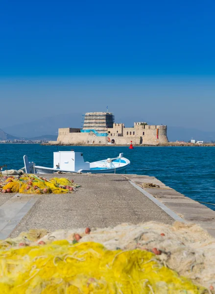 Fischerboot und Fischernetze mit Burg Bourtzi im Hintergrund, nafplio, Griechenland — Stockfoto