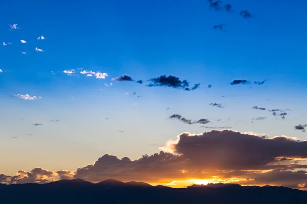 Vista panoramica di un bellissimo tramonto con cielo blu e nuvole sulle montagne — Foto Stock