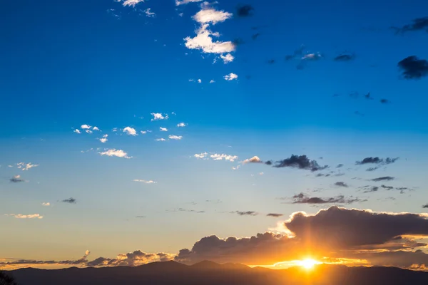 Vista panoramica di un bellissimo tramonto con cielo blu e nuvole sulle montagne — Foto Stock