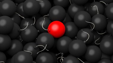 Siyah bomba yığını üzerinde yalan bir kırmızı bomba gösteren resim