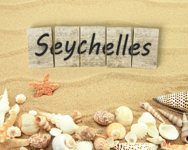 Seychelles on wooden board pieces with sea shells and sand — Stock Photo, Image