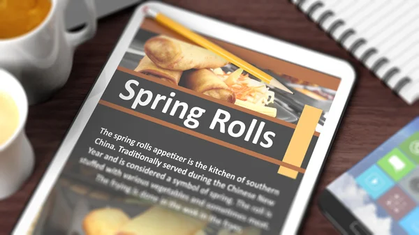 Tabletop with various objects focused on tablet with recipe of "Spring Rolls" on screen — Stock Photo, Image