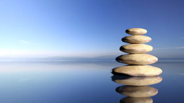 Zen Steine stapeln sich von groß bis klein im Wasser mit blauem Himmel und friedlichem Landschaftshintergrund. — Stockfoto