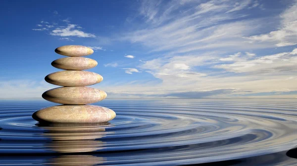 Zen-Steine stapeln sich von groß bis klein im Wasser mit kreisförmigen Wellen und friedlichem Himmel. — Stockfoto