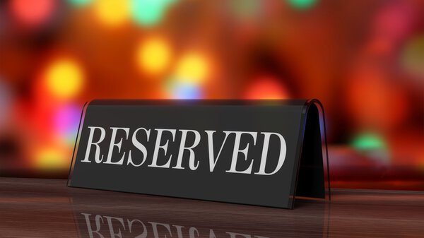 Черный глянцевый знак резервации на деревянной поверхности, на праздничном фоне
.