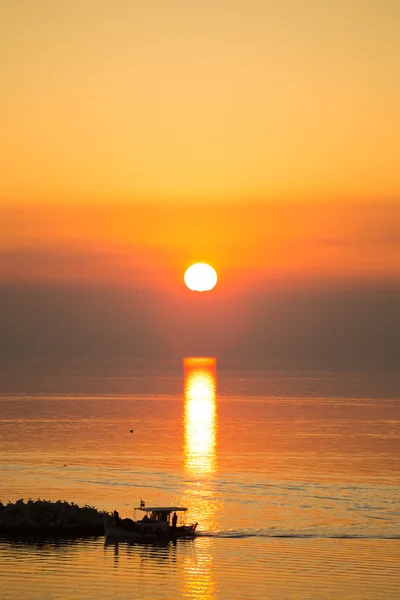 Disco solar reflejándose en la superficie del mar, con el color naranja dominando el paisaje marino —  Fotos de Stock