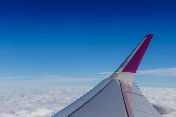 Modrý horizont a bílé mraky. Letecký snímek s křídlem letadla — Stock fotografie