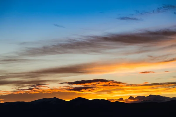 Majestátní živé západ slunce/svítání s mraky nad temnými horami siluety — Stock fotografie