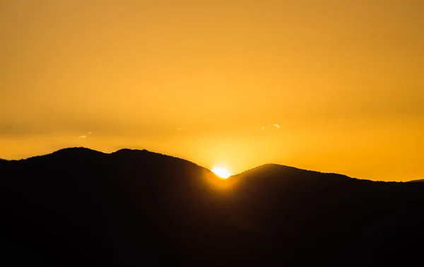 Maestoso tramonto vivido / alba sulle sagome delle montagne scure — Foto Stock