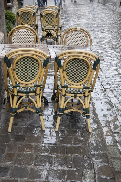 Cafétische und Stühle in der nassen, regnerischen Straße in Brüssel — Stockfoto