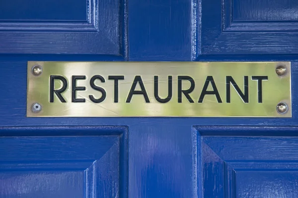 蓝门上的餐厅标志 — 图库照片