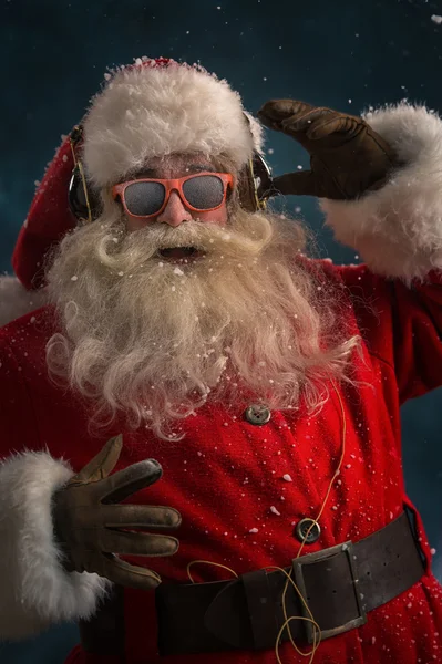 Santa claus lyssna på musik i hörlurar Stockfoto
