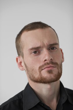 Genç işadamı kameraya bakıyor.