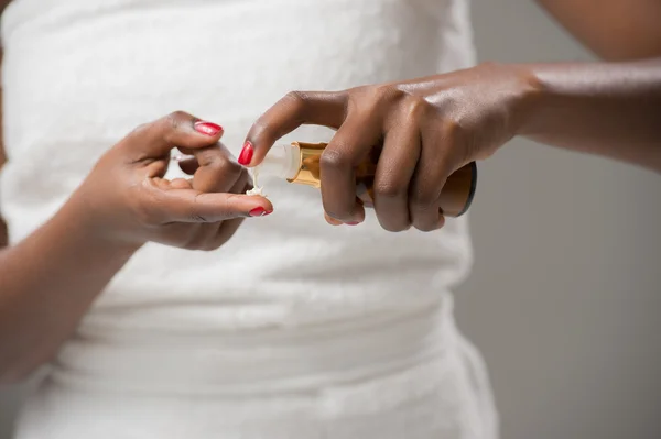 Mujer africana aplicando crema — Foto de Stock