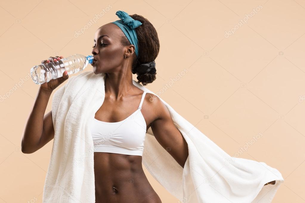 Sporty woman drinking water