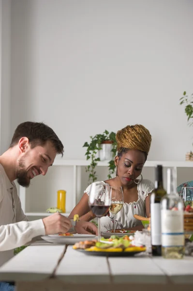 Casal multirracial desfrutando refeição — Fotografia de Stock