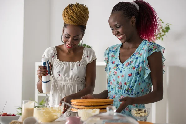 African women cooking cake with strawberries — Stock Photo, Image