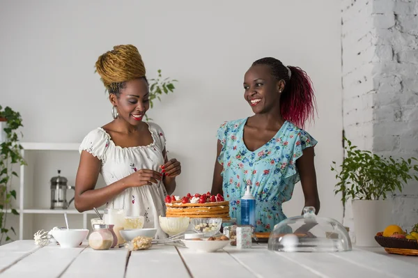 Mujeres africanas cocinando pastel con fresas — Foto de Stock