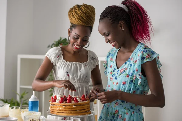 African women cooking cake with strawberries — Stock Photo, Image